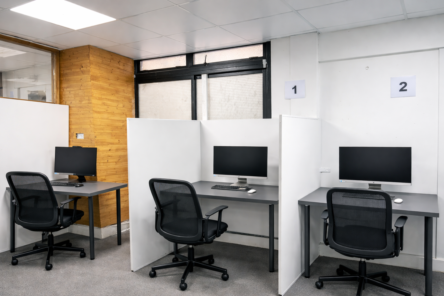 ACCA CBE exam workstations at Ark Education Centre Ilford — numbered bays with privacy dividers