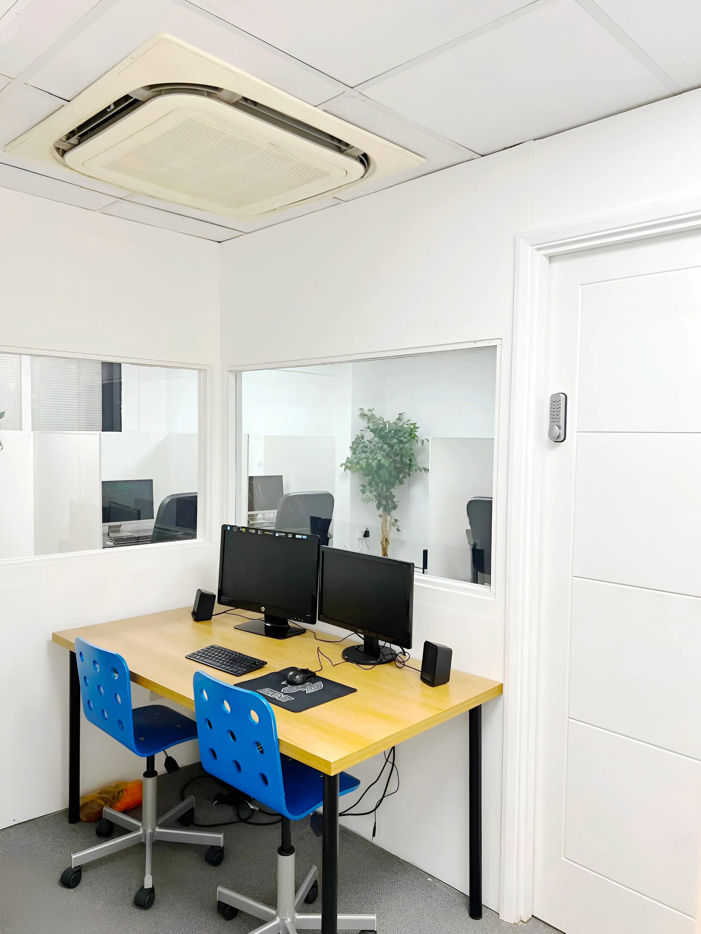 Computer workstation room at Ark Education Centre Ilford — secure keypad access, dual monitors, individual supervised workspace